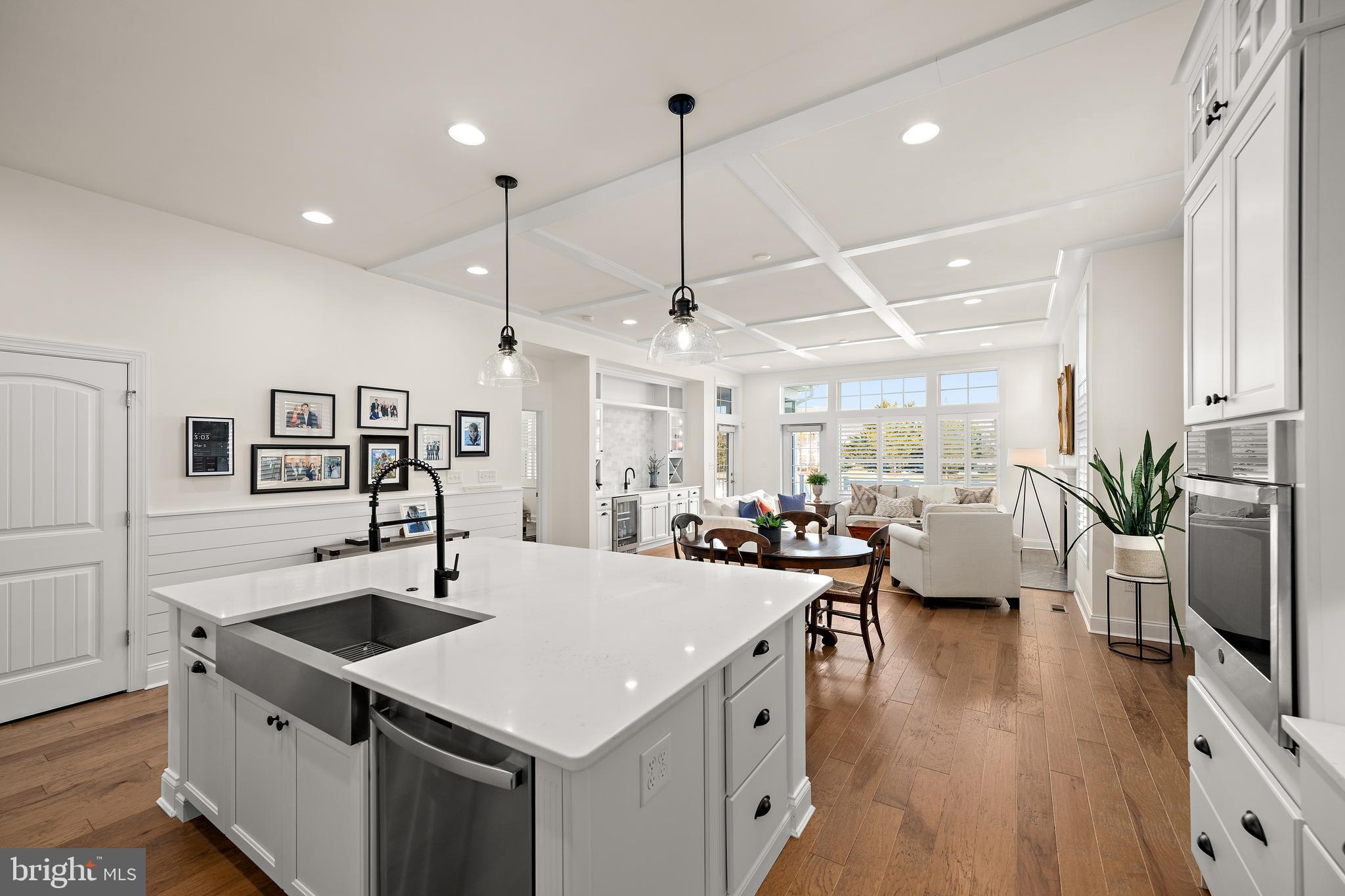 11119 Marvil Road, Unit 93 Lewes, DE 19958 - Photo 5 of 52 a kitchen with a stove a refrigerator a sink dishwasher with a dining table and chairs with wooden floor