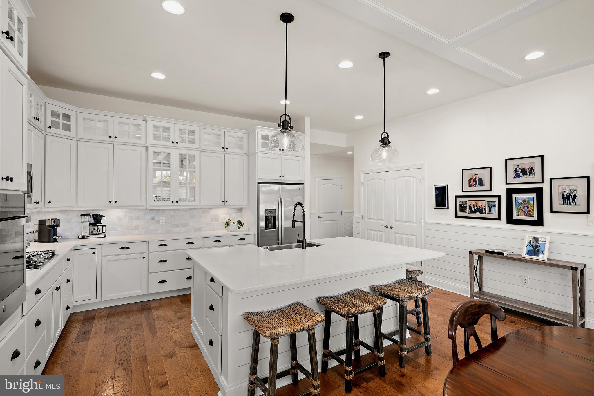 11119 Marvil Road, Unit 93 Lewes, DE 19958 - Photo 6 of 52 a kitchen with stainless steel appliances sink stove and white cabinets with wooden floor