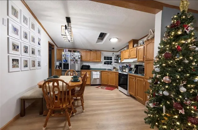 a kitchen with granite countertop a table chairs stainless steel appliances and cabinets