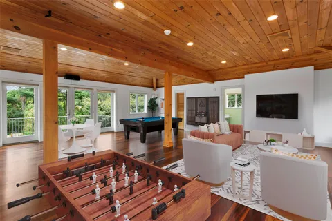 a living room with furniture a flat screen tv and a large window