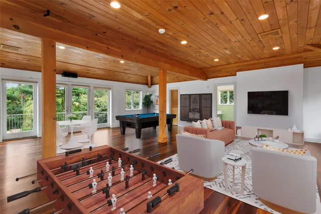 a living room with furniture a flat screen tv and a large window