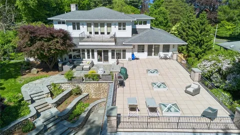 a view of a white house with a chairs in patio