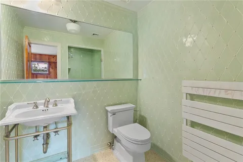 a bathroom with a toilet sink and mirror