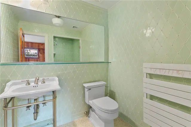 a bathroom with a toilet sink and mirror