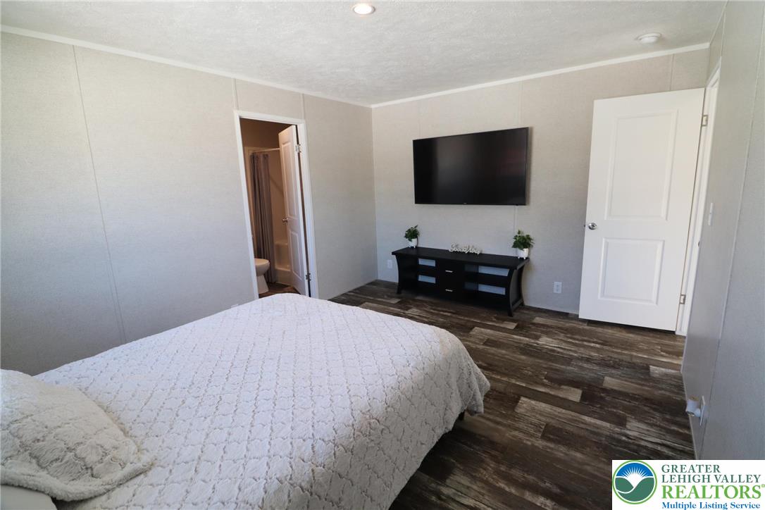 5016 Old Timber Road Stroudsburg, PA 18360 - Photo 16 of 34 a bedroom with a bed and a flat screen tv