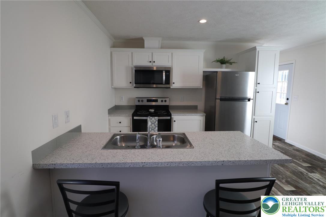 5016 Old Timber Road Stroudsburg, PA 18360 - Photo 9 of 34 a kitchen with kitchen island a sink stainless steel appliances and cabinets