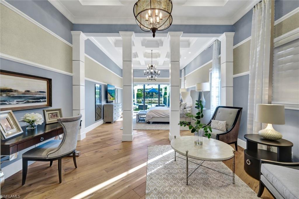 16988 Fairgrove Way Naples, FL 34110 - Photo 14 of 34 a living room with furniture a chandelier and a mirror