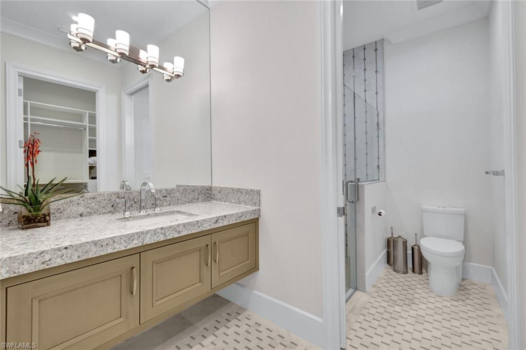 16988 Fairgrove Way Naples, FL 34110 - Photo 18 of 34 a bathroom with a granite countertop sink a toilet and a mirror