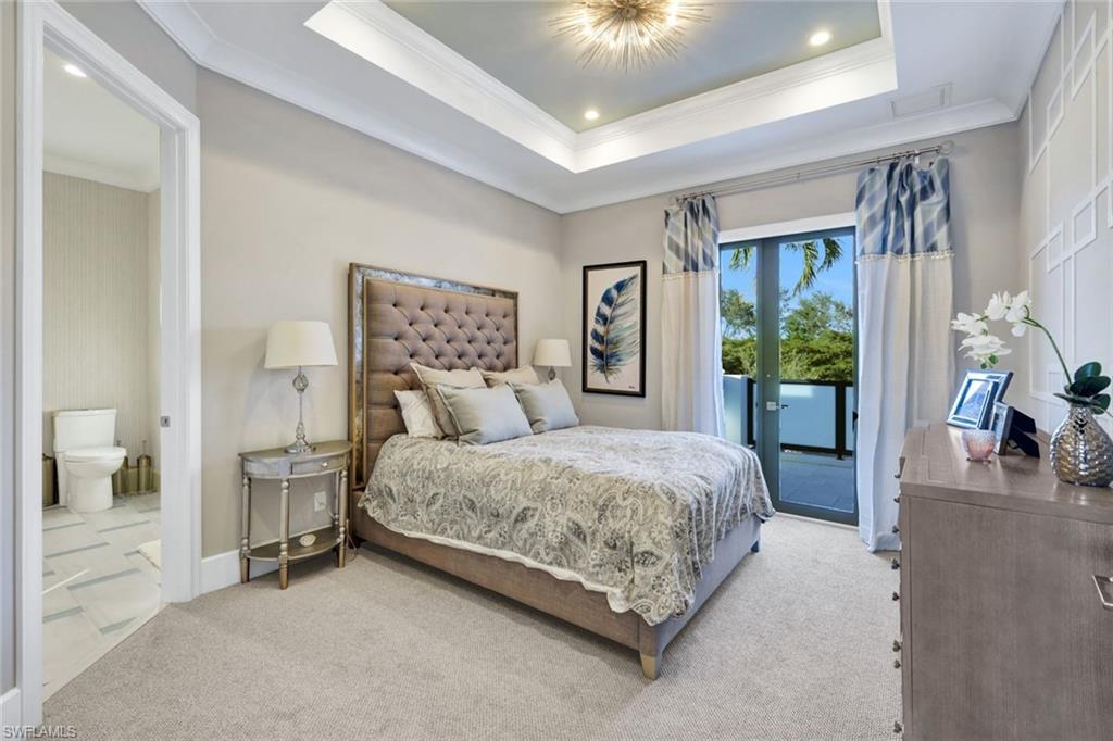 16988 Fairgrove Way Naples, FL 34110 - Photo 19 of 34 a spacious bedroom with a bed and large windows