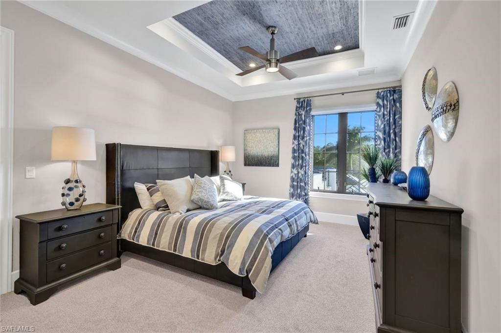 16988 Fairgrove Way Naples, FL 34110 - Photo 21 of 34 a bedroom with a bed and a chandelier