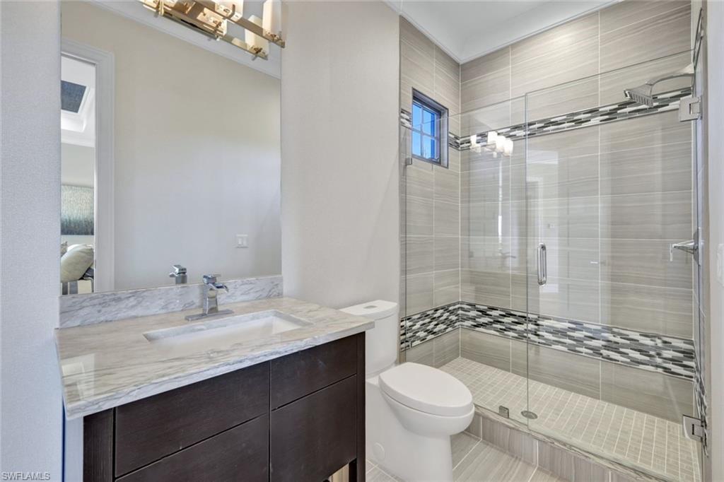 16988 Fairgrove Way Naples, FL 34110 - Photo 22 of 34 a bathroom with a granite countertop sink toilet and shower