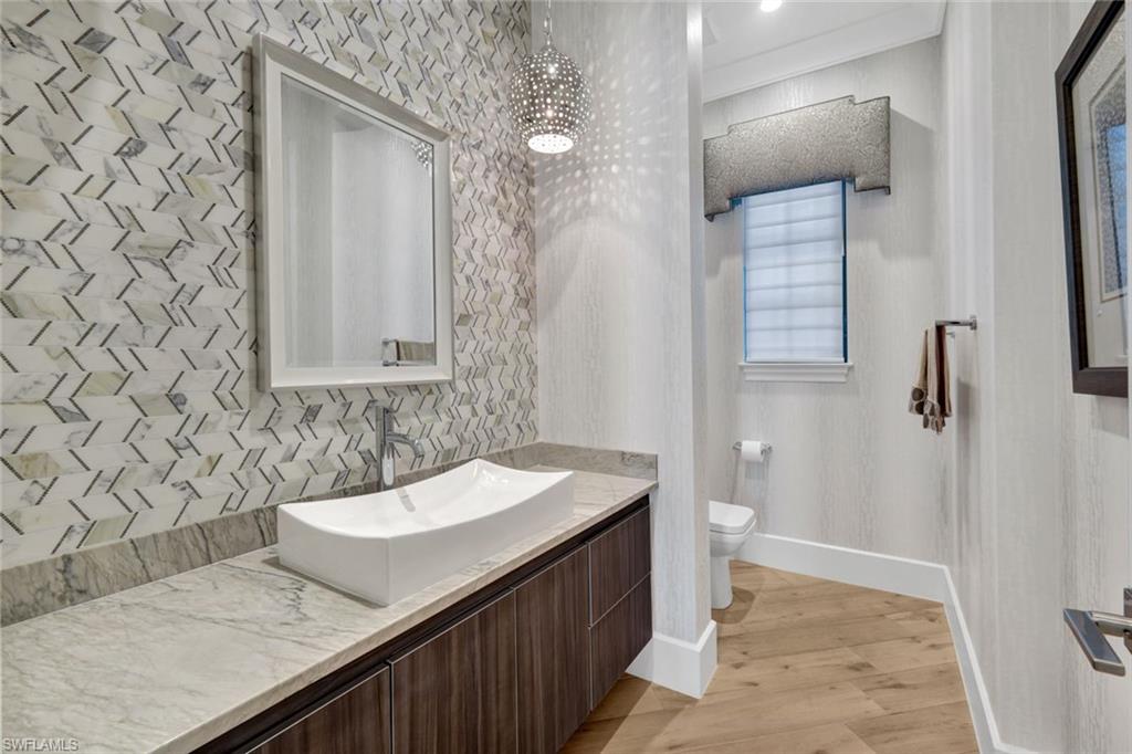 16988 Fairgrove Way Naples, FL 34110 - Photo 23 of 34 a bathroom with a sink and a mirror
