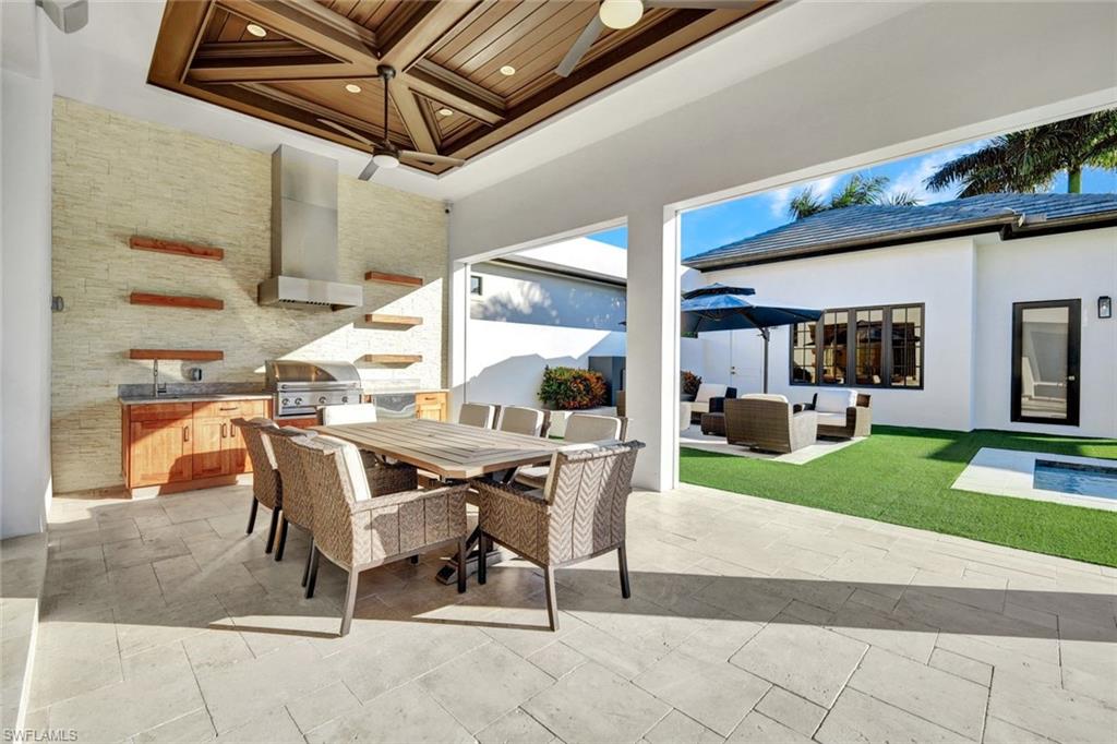 16988 Fairgrove Way Naples, FL 34110 - Photo 26 of 34 a view of a patio with table and chairs and a barbeque