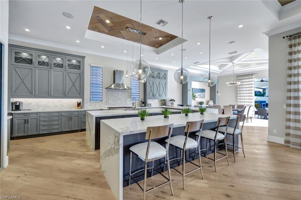 16988 Fairgrove Way Naples, FL 34110 - Photo 8 of 34 a kitchen with a table chairs sink and cabinets