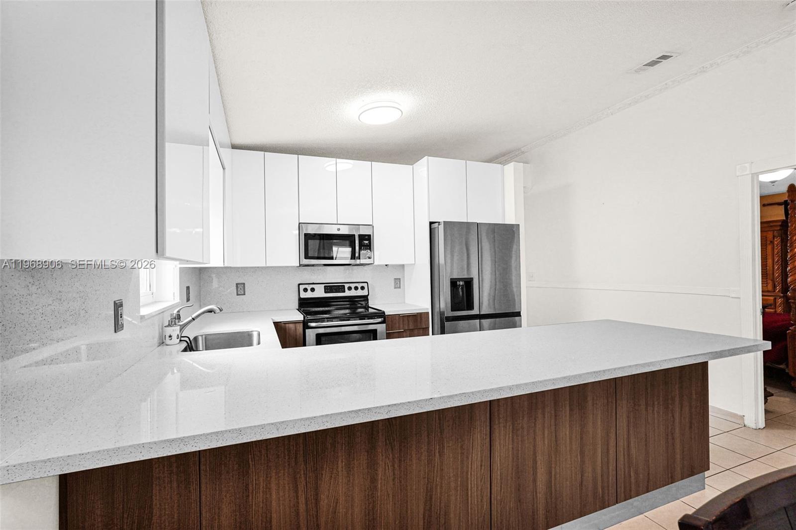 3289 West 70th Street Hialeah, FL 33018 - Photo 11 of 50 a kitchen with stainless steel appliances a refrigerator sink and white cabinets