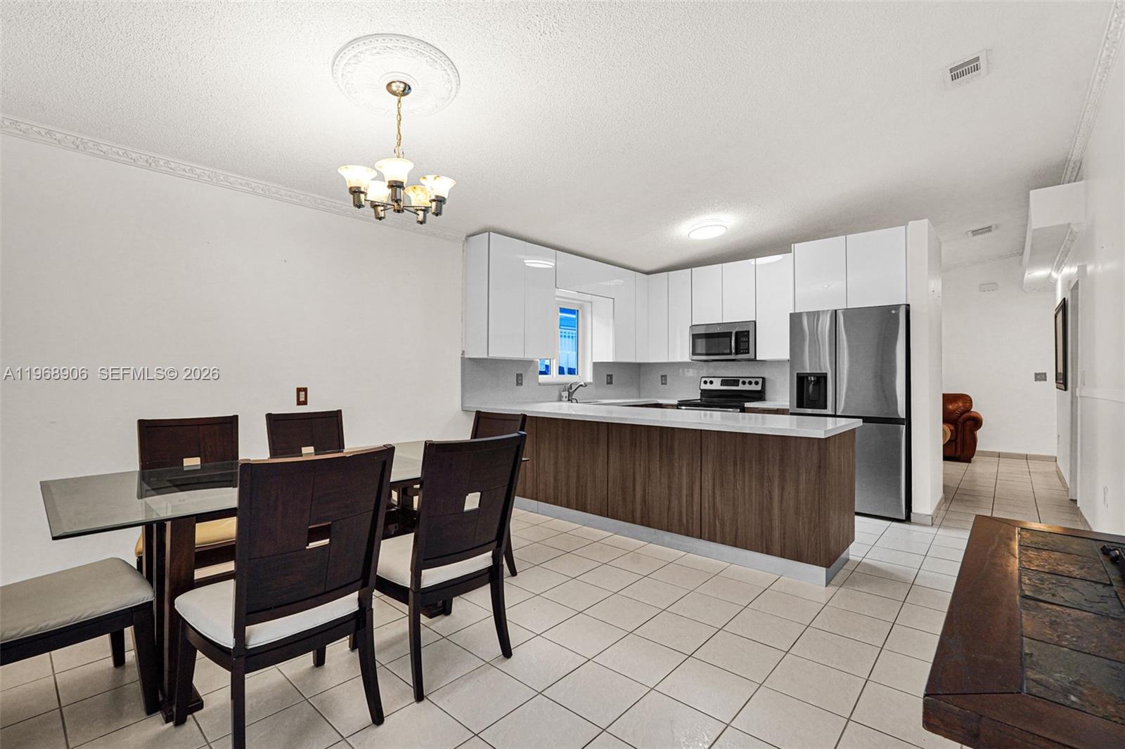 3289 West 70th Street Hialeah, FL 33018 - Photo 14 of 50 a kitchen with a dining table chairs and refrigerator