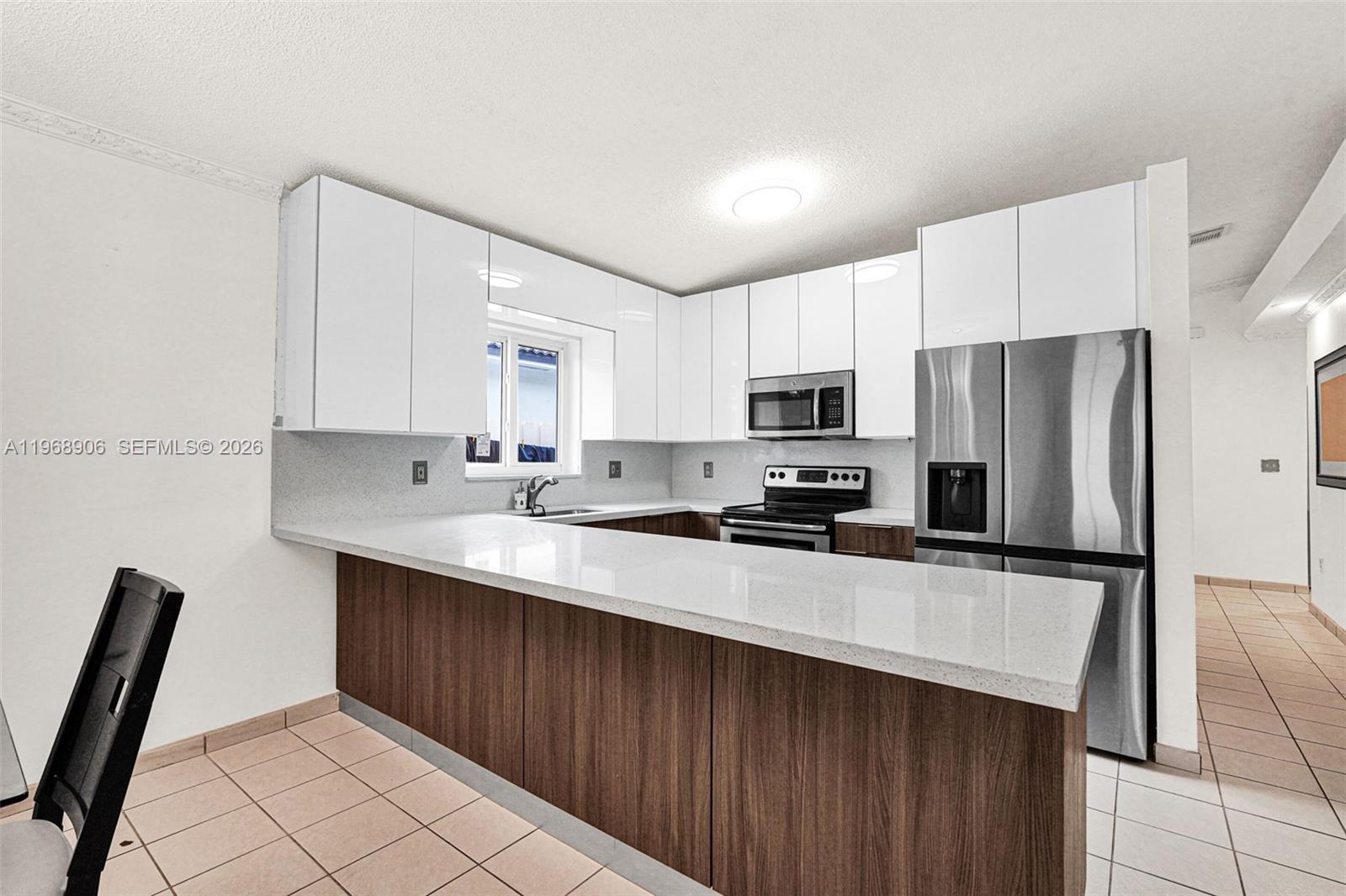 3289 West 70th Street Hialeah, FL 33018 - Photo 6 of 50 a kitchen with a refrigerator a sink and cabinets