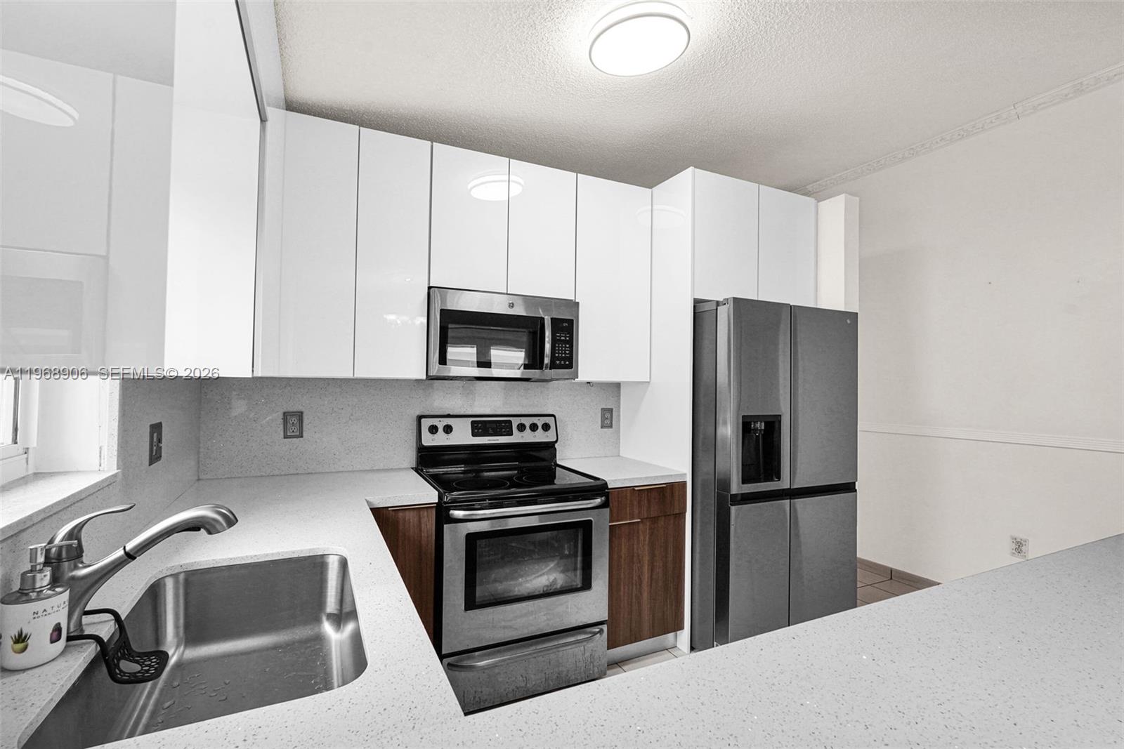 3289 West 70th Street Hialeah, FL 33018 - Photo 7 of 50 a kitchen with stainless steel appliances a refrigerator stove and white cabinets