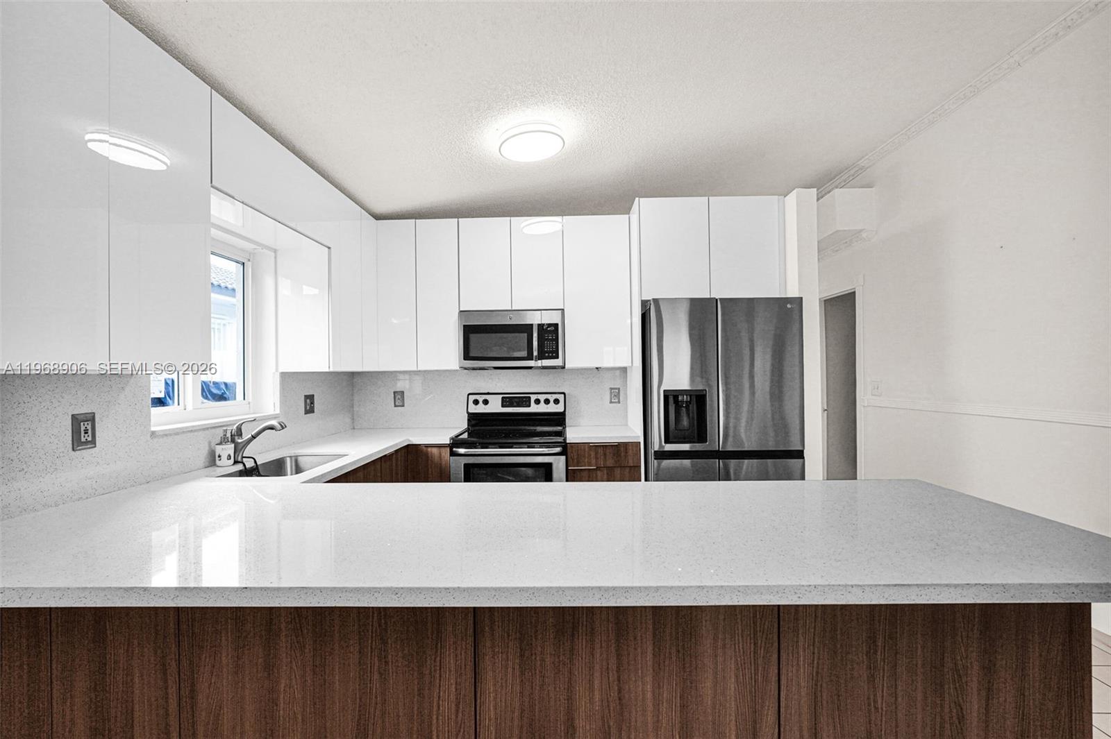 3289 West 70th Street Hialeah, FL 33018 - Photo 9 of 50 a kitchen with stainless steel appliances a refrigerator sink and microwave