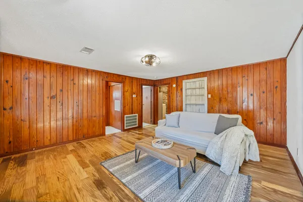 a living room with furniture and a wooden floor