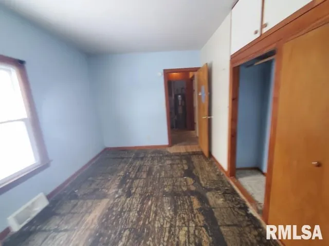 a view of hallway with window and wooden floor