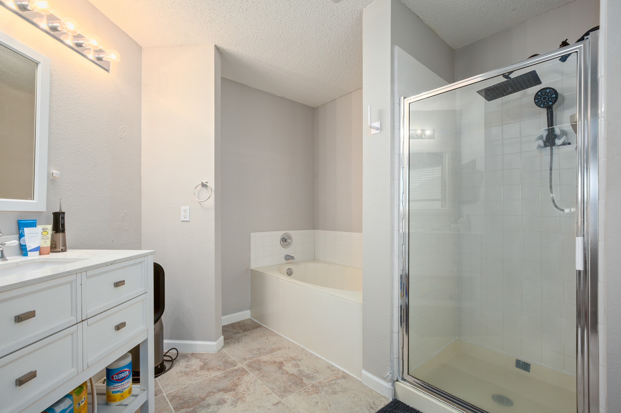 13803 Randalstone Drive Pflugerville, TX 78660 - Photo 24 of 27 Full bathroom featuring vanity, a bath, a stall shower, and a textured ceiling