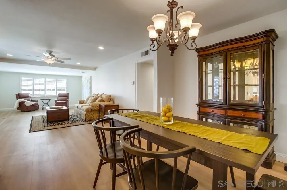 16632 Roca Drive San Diego, CA 92128 - Photo 12 of 44 a view of a dining room with furniture a chandelier and wooden floor