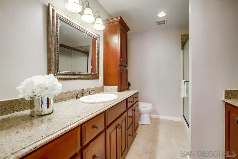 16632 Roca Drive San Diego, CA 92128 - Photo 23 of 44 a bathroom with a granite countertop sink and a mirror