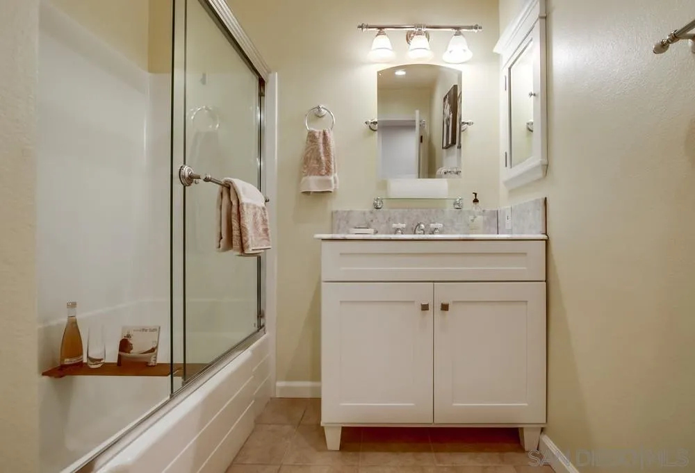 16632 Roca Drive San Diego, CA 92128 - Photo 29 of 44 a bathroom with a sink a mirror and shower