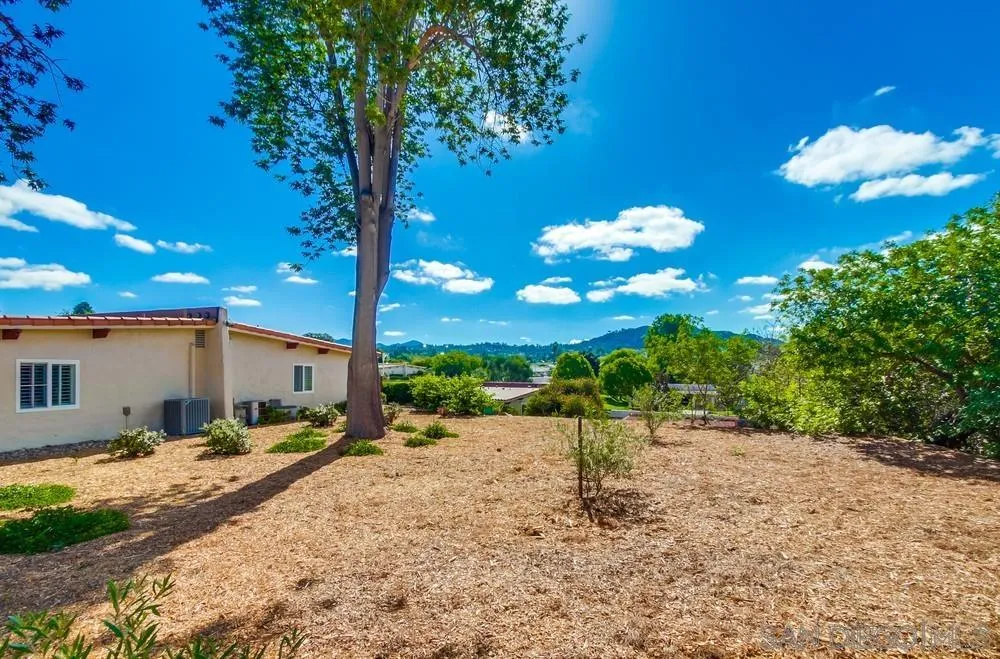 16632 Roca Drive San Diego, CA 92128 - Photo 37 of 44 a backyard of a house with table and chairs under an umbrella