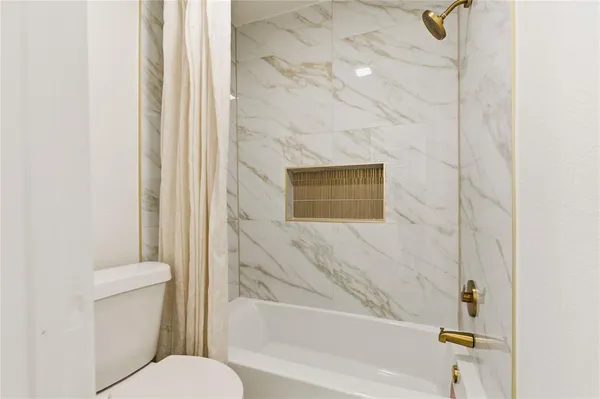 a bathroom with a toilet and a shower