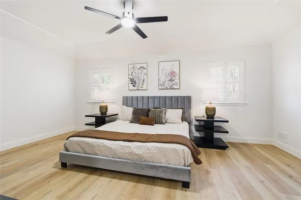 a bedroom with a bed and wooden floor