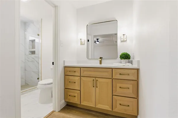 a bathroom with a granite countertop sink toilet and shower
