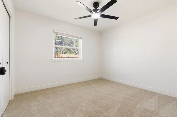 an empty room with a window and a fan