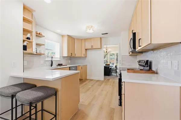 a kitchen with stainless steel appliances granite countertop a sink stove and refrigerator