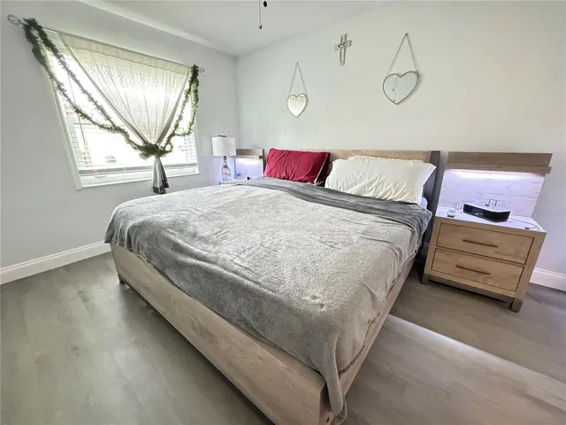 a bedroom with a bed and wooden floor