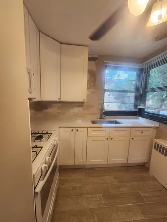 a kitchen with granite countertop a sink a stove top oven and cabinets