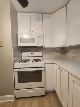a stove top oven sitting inside of a kitchen