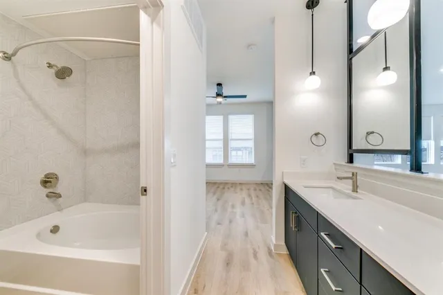a bathroom with a tub sink and mirror