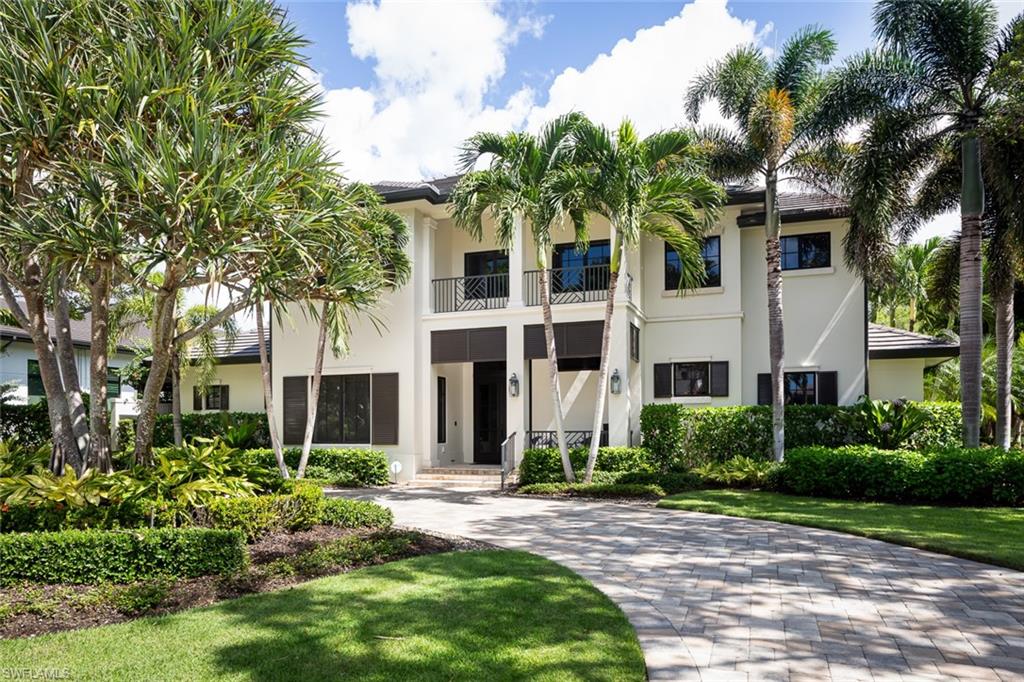 3170 Crayton Road Naples, FL 34103 - Photo 1 of 50 a front view of a house with a garden
