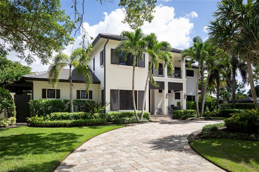 3170 Crayton Road Naples, FL 34103 - Photo 38 of 50 a front view of a house with a yard and potted plants