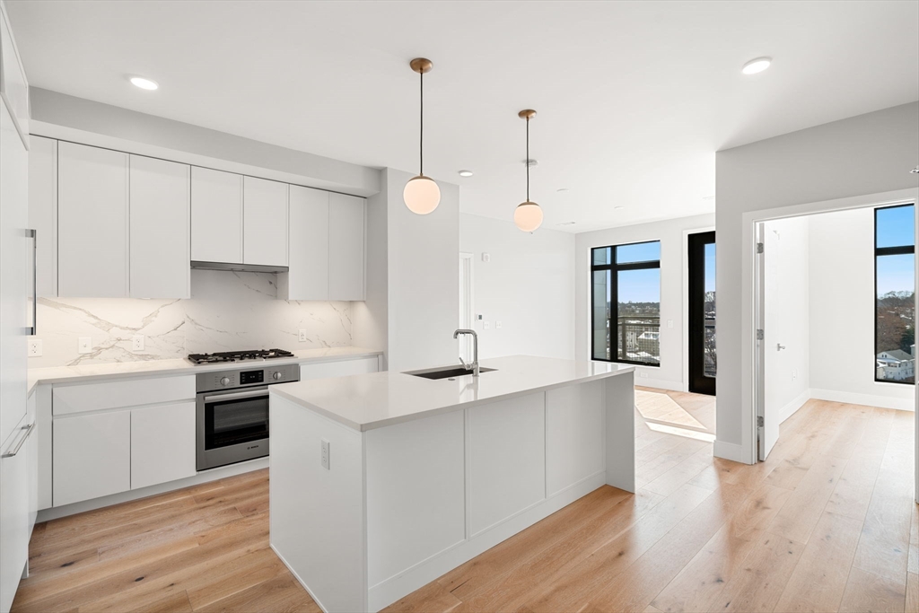 a kitchen with stainless steel appliances granite countertop a white stove top oven and cabinets