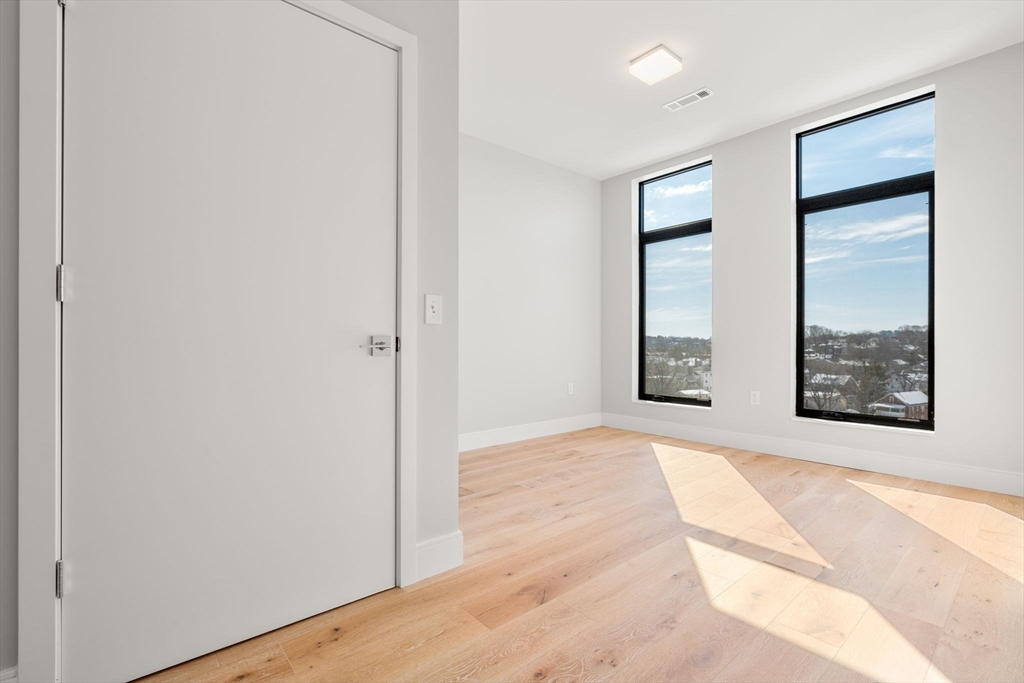 191 Washington Street, Unit 710 Boston, MA 02135 - Photo 12 of 35 an empty room with windows and closet