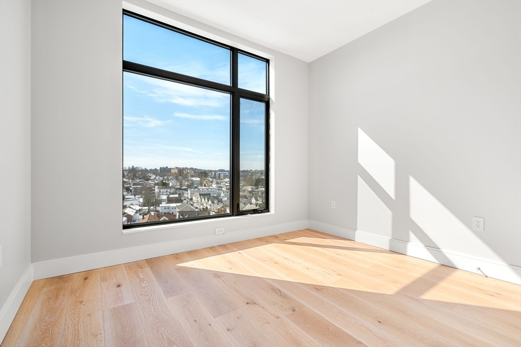191 Washington Street, Unit 710 Boston, MA 02135 - Photo 14 of 35 a view of an empty room with wooden floor and a window