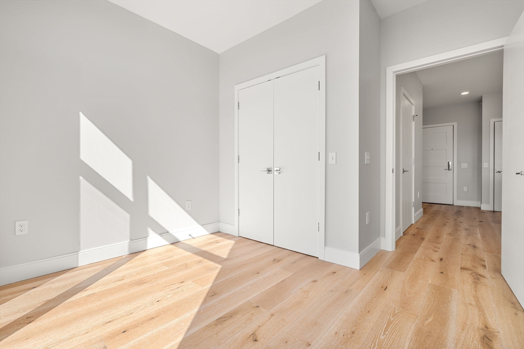 191 Washington Street, Unit 710 Boston, MA 02135 - Photo 15 of 35 a view of a big room with wooden floor and staircase