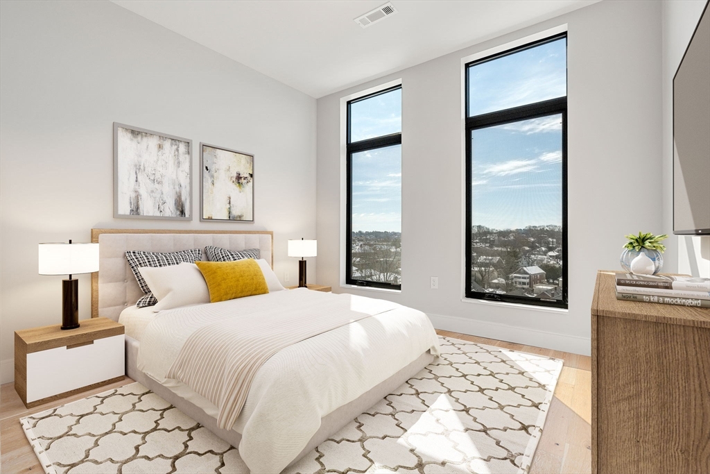 191 Washington Street, Unit 710 Boston, MA 02135 - Photo 9 of 35 a bedroom with a large bed and a window