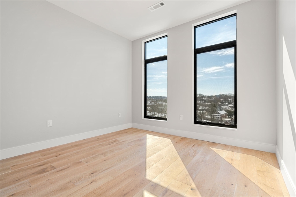 191 Washington Street, Unit 710 Boston, MA 02135 - Photo 10 of 35 an empty room with windows and closet