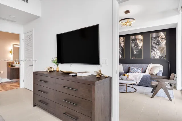 a bedroom with a bed and a flat screen tv