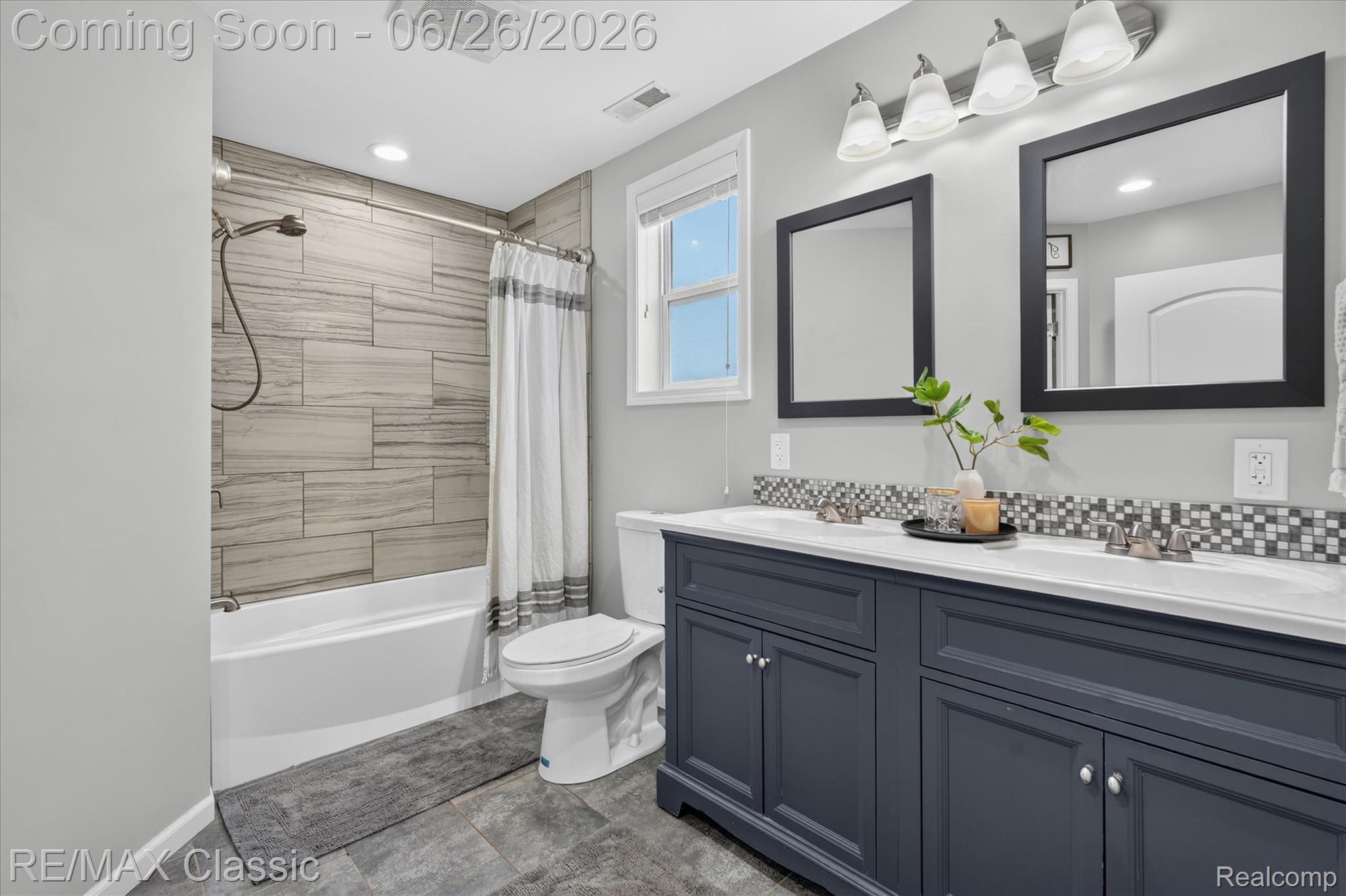 3205 North Milford Road Highland, MI 48357 - Photo 19 of 53 Full bathroom featuring a dual vanity with a dark blue cabinet base, white countertops, and square black-framed mirrors