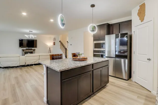 a kitchen with stainless steel appliances granite countertop a sink a stove and a refrigerator
